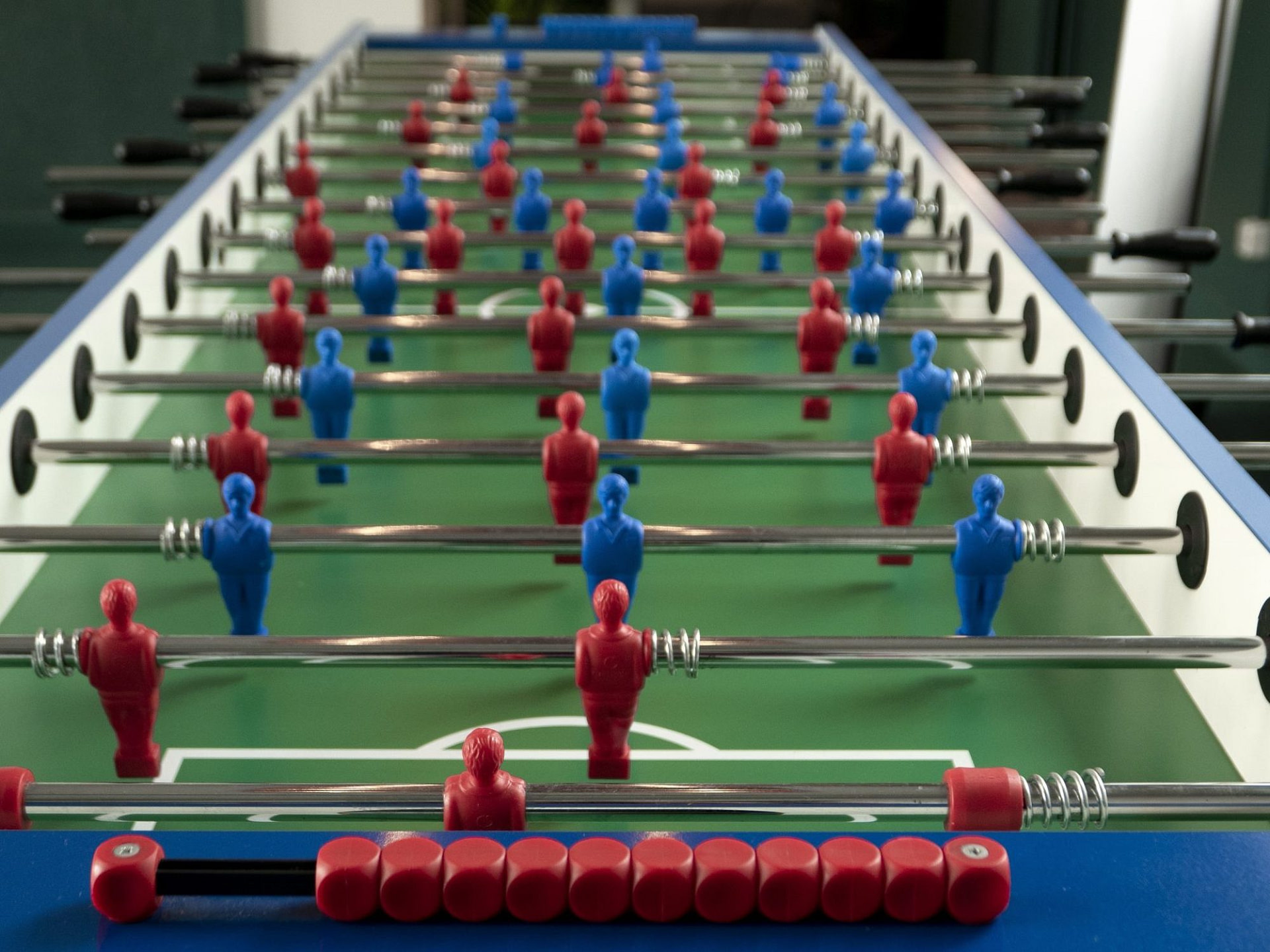 A high angle shot of a foosball game with blue and red figurines