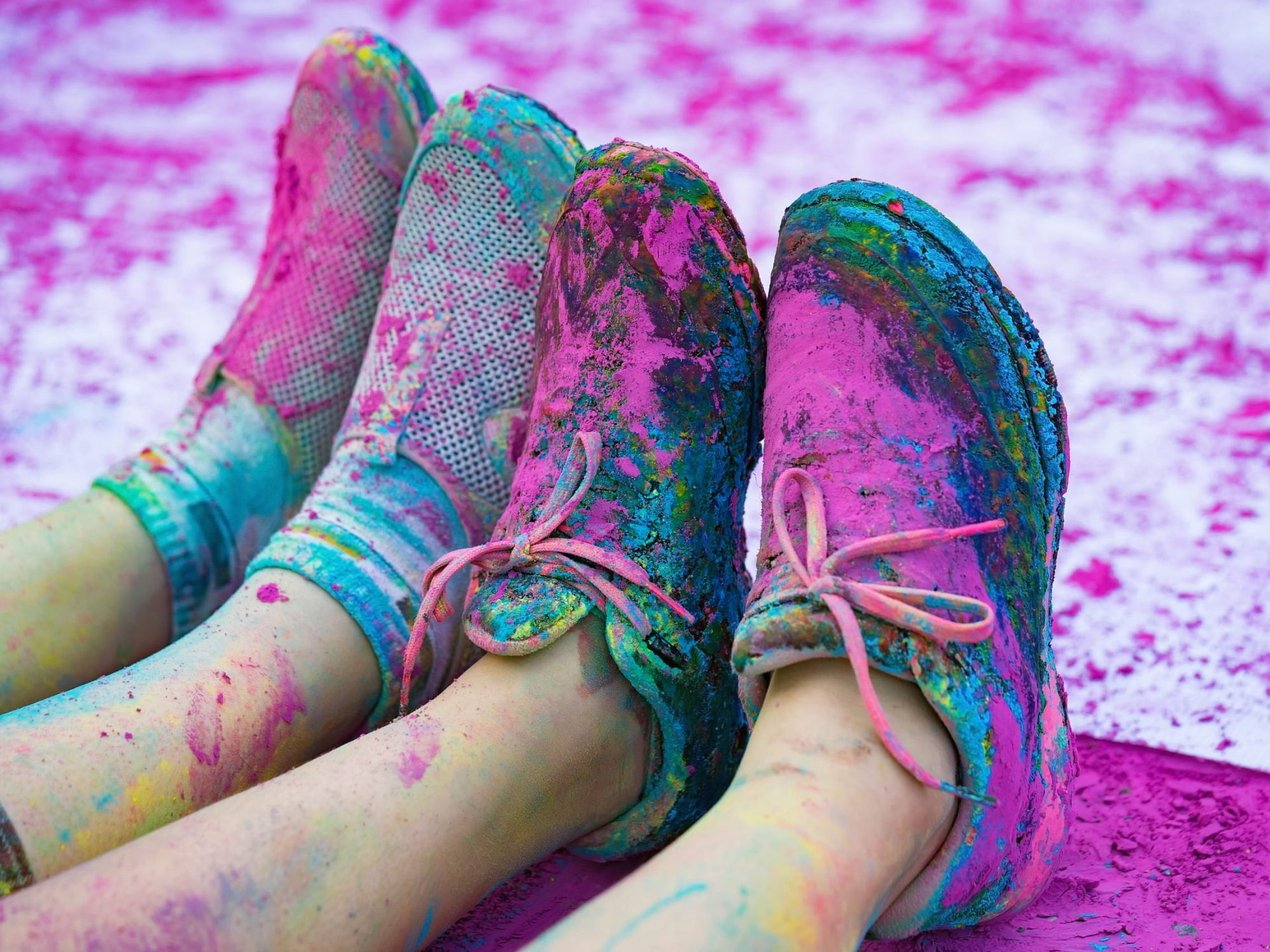 The colorful shoes and legs of teenagers with purple color powder in the public event The Color Run